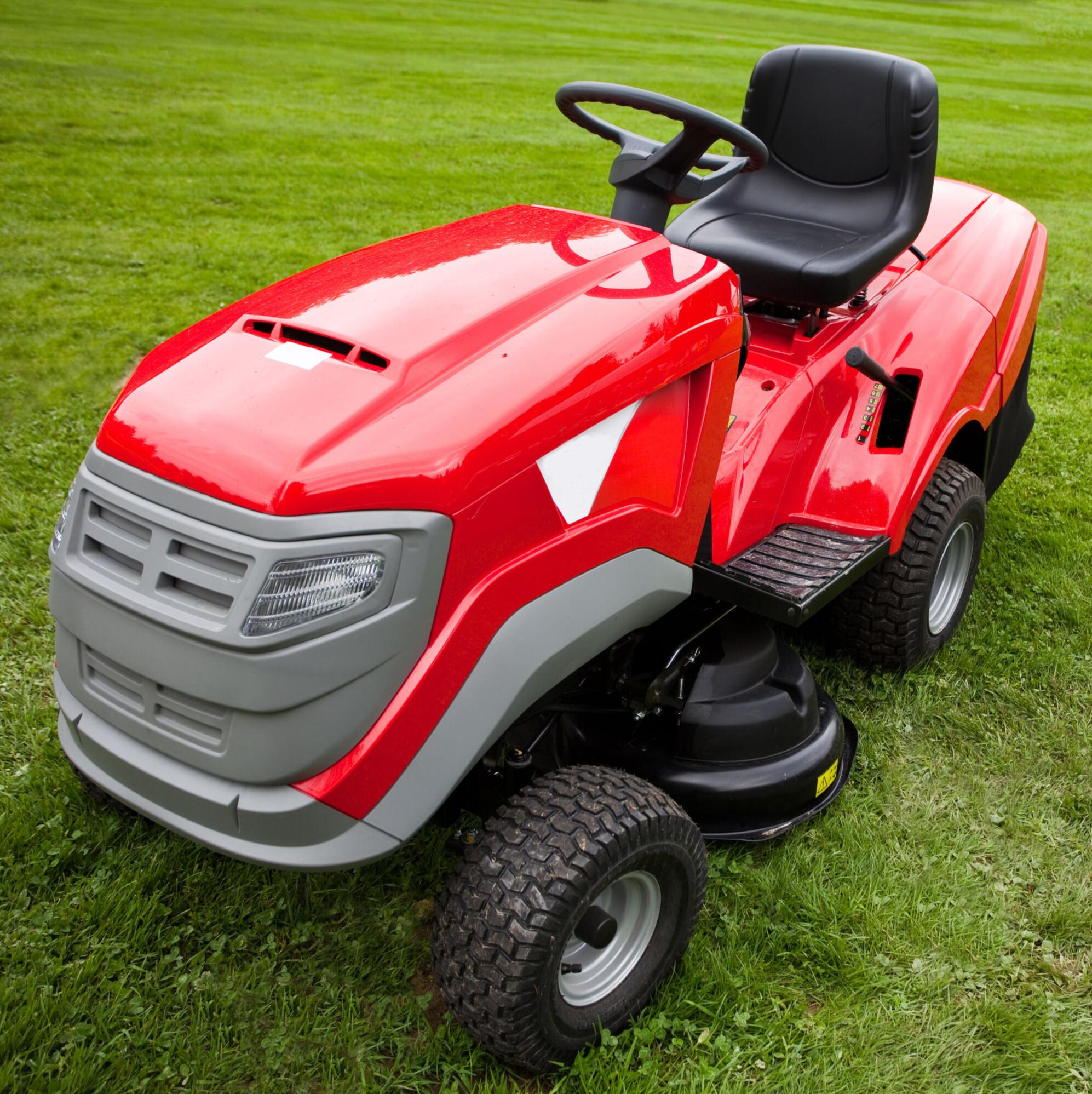 red riding mower on green grass